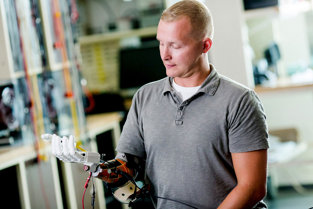 Disabled veteran wearing prosthetic hand developed by engineering graduate student.